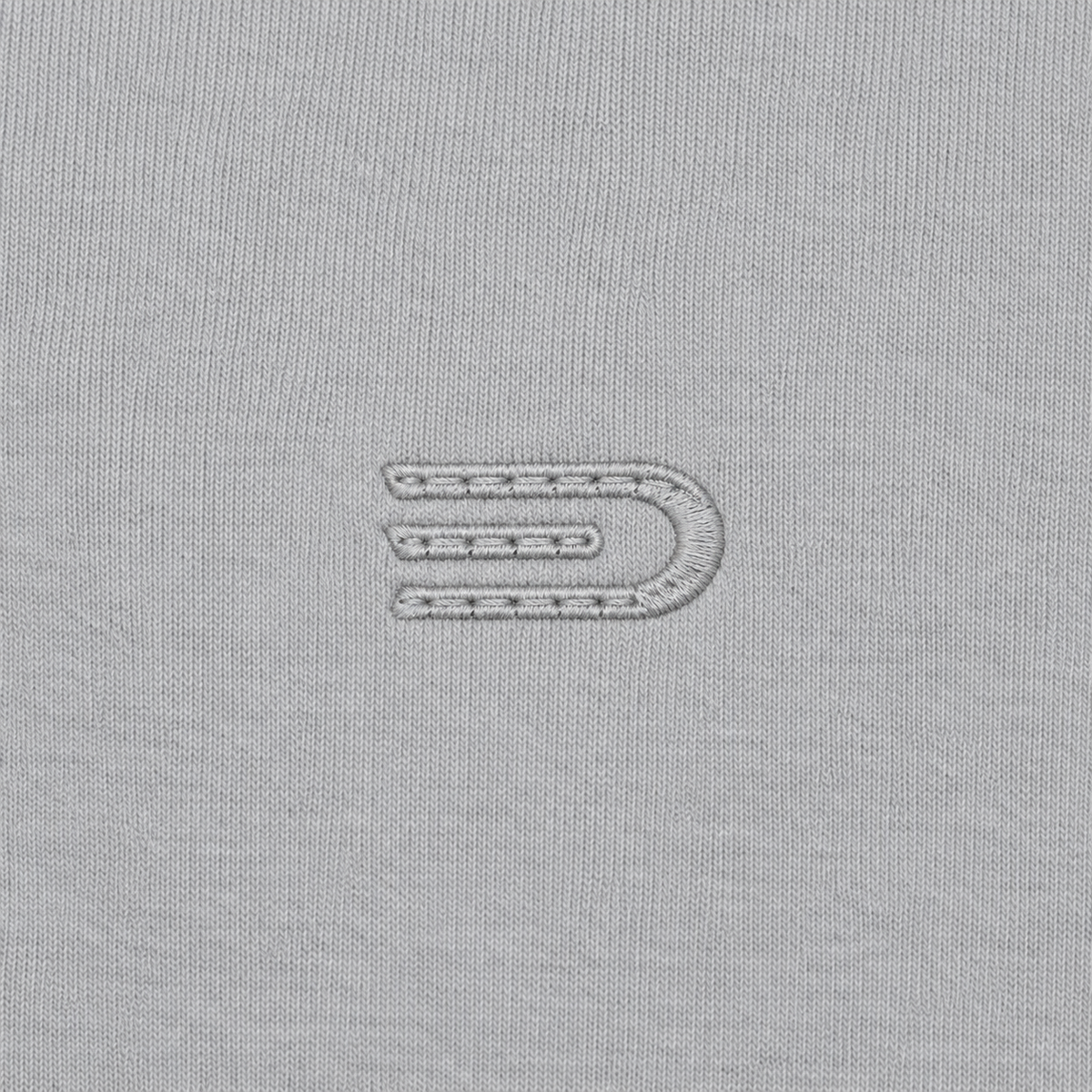 Close detail of tonal Douglas D emblem on light grey heavyweight sweatshirt